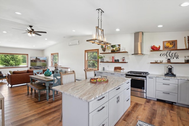 10200 Jerome Rd N, Jerome, MI 49249 - kitchen with stainless steel range with gas stovetop, open shelves, wall chimney range hood, an AC wall unit, and a ceiling fan