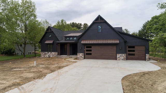 2750 Ashford Trl, Portage, MI 49024 - modern inspired farmhouse with a standing seam roof, stone siding, driveway, and metal roof