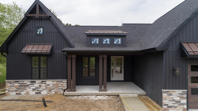 2750 Ashford Trl, Portage, MI 49024 - doorway to property featuring stone siding, a shingled roof, and a porch