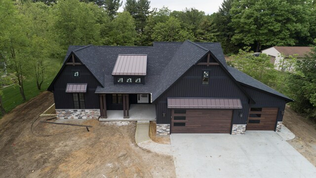 2750 Ashford Trl, Portage, MI 49024 - view of front of property with a standing seam roof, roof with shingles, driveway, metal roof, and stone siding