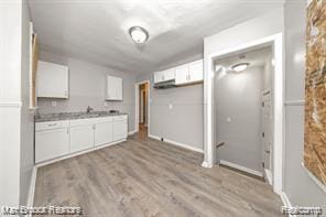 17167 Salem St, Detroit, MI 48219 - kitchen featuring white cabinetry, wood finished floors, light countertops, and baseboards
