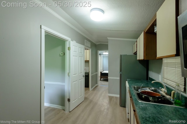 10531 Devils Lake Hwy, Addison, MI 49220 - kitchen with light wood-style flooring, dark countertops, crown molding, freestanding refrigerator, and a textured ceiling