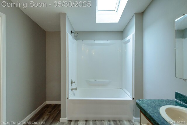 10531 Devils Lake Hwy, Addison, MI 49220 - bathroom with a skylight, wood finished floors, vanity, shower / bathtub combination, and baseboards