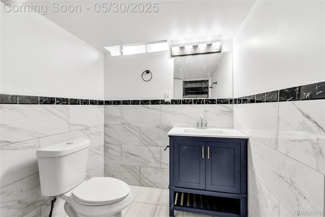 7278 Superior, Center Line, MI 48015 - bathroom featuring tile walls, toilet, vanity, a wainscoted wall, and tile patterned flooring
