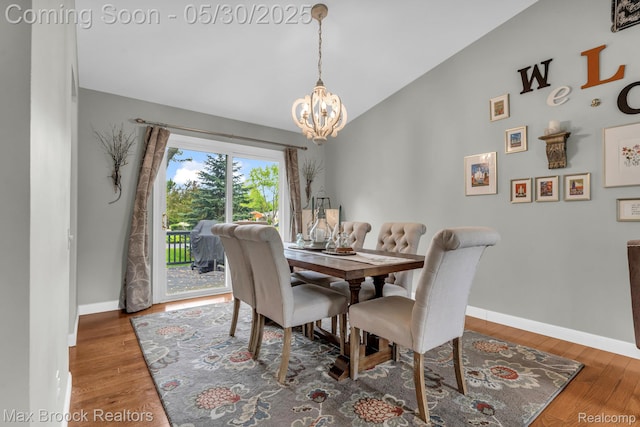 591 S Spinningwheel Ln, Bloomfield Hills, MI 48304 - dining space featuring a chandelier, baseboards, lofted ceiling, and wood finished floors