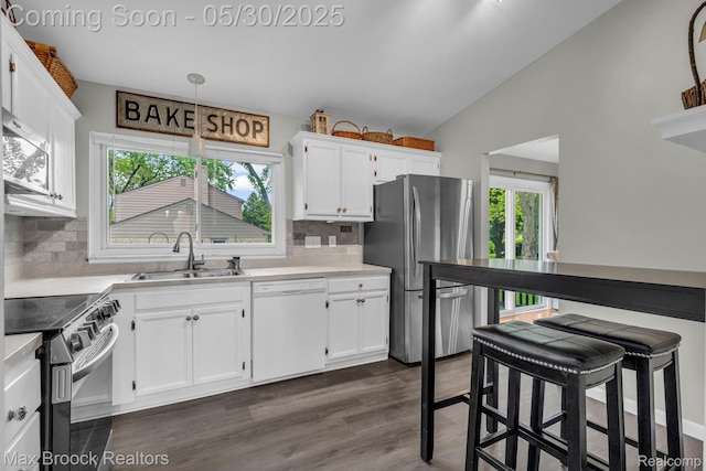 591 S Spinningwheel Ln, Bloomfield Hills, MI 48304 - kitchen with appliances with stainless steel finishes, a sink, lofted ceiling, white cabinetry, and light countertops
