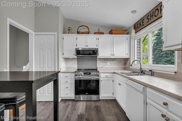 591 S Spinningwheel Ln, Bloomfield Hills, MI 48304 - kitchen featuring appliances with stainless steel finishes, vaulted ceiling, a sink, white cabinets, and tasteful backsplash