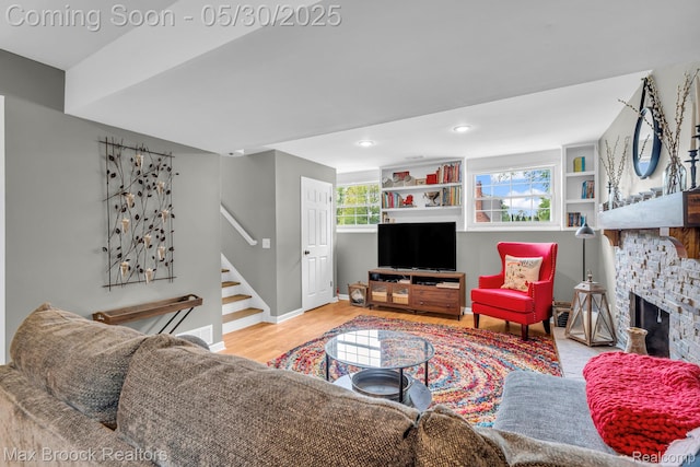 591 S Spinningwheel Ln, Bloomfield Hills, MI 48304 - living area featuring stairs, wood finished floors, a stone fireplace, baseboards, and recessed lighting