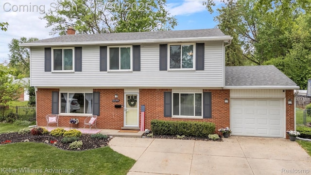 23355 Larkshire St, Farmington Hills, MI 48336 - view of front of house with a chimney, a garage, driveway, and brick siding