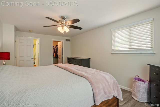 23355 Larkshire St, Farmington Hills, MI 48336 - bedroom with wood finished floors, baseboards, a walk in closet, a ceiling fan, and a closet
