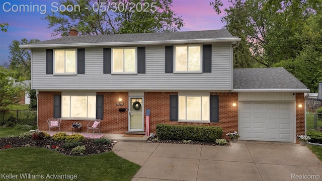 23355 Larkshire St, Farmington Hills, MI 48336 - colonial inspired home with an attached garage, a chimney, driveway, and brick siding