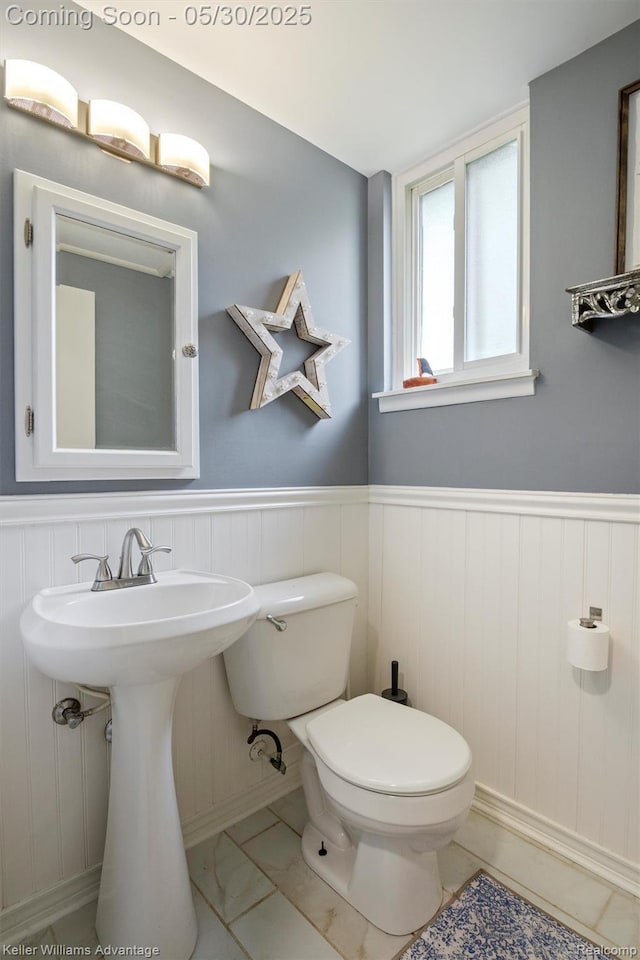 23355 Larkshire St, Farmington Hills, MI 48336 - bathroom featuring toilet, marble look tile flooring, wainscoting, and baseboards