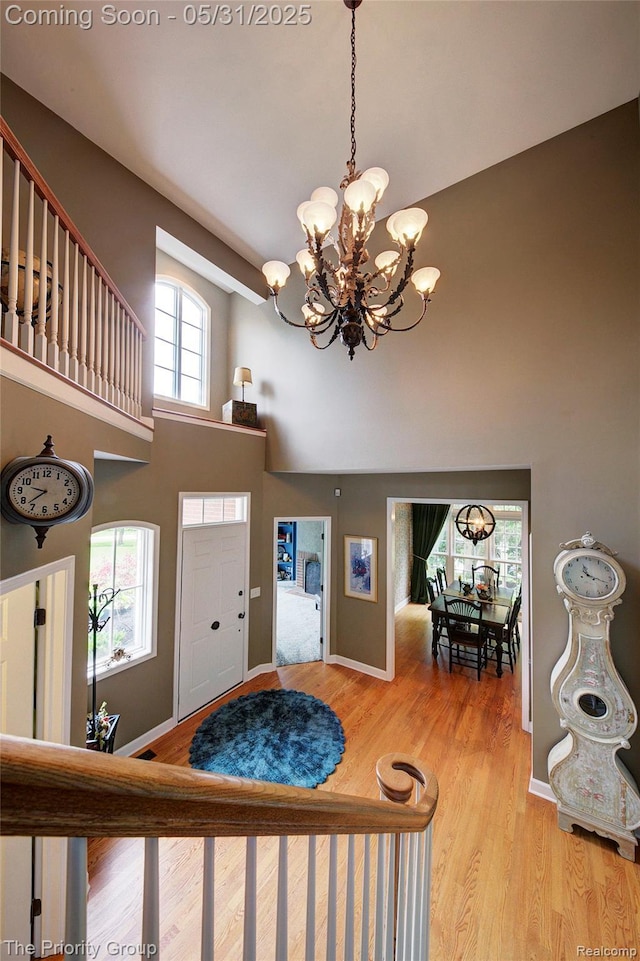 7730 Parkcrest Cir, Clarkston, MI 48348 - entryway featuring a towering ceiling, a chandelier, wood finished floors, and baseboards