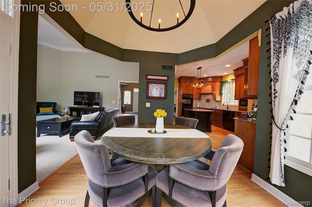 7730 Parkcrest Cir, Clarkston, MI 48348 - dining room with a chandelier, light wood-style flooring, a high ceiling, and baseboards