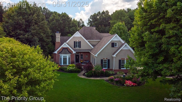 7730 Parkcrest Cir, Clarkston, MI 48348 - traditional-style house with a chimney, a front lawn, and stucco siding