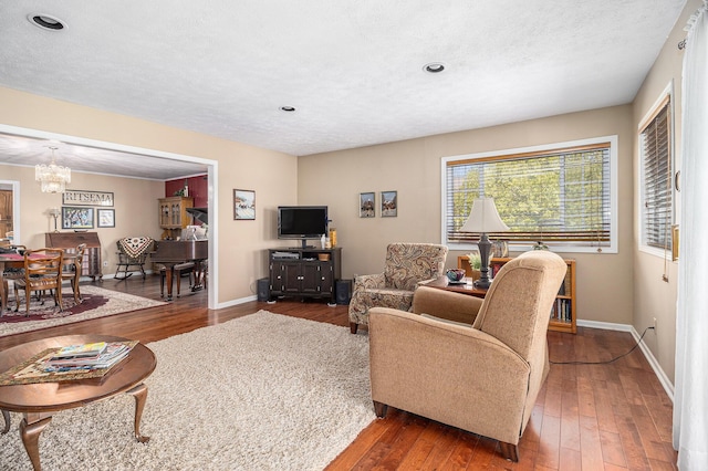 280 Rasmussen Dr, Trufant, MI 49347 - living room with a chandelier, wood-type flooring, baseboards, recessed lighting, and a textured ceiling