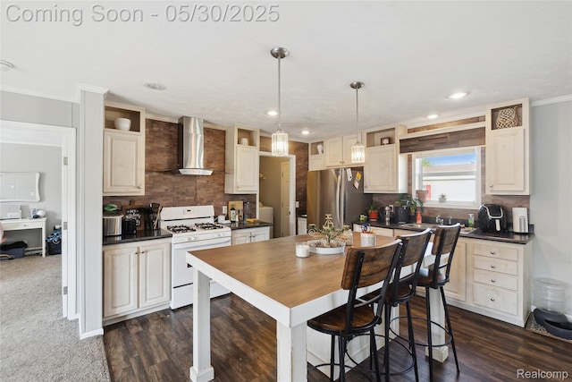 29 Fox Hound Ct, Grand Blanc, MI 48439 - kitchen with wall chimney exhaust hood, white range with gas stovetop, freestanding refrigerator, dark countertops, and crown molding