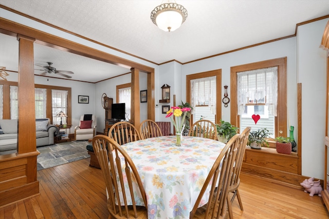 708 S Laurel St, Royal Oak, MI 48067 - dining area featuring light wood-style flooring, crown molding, ornate columns, and a ceiling fan