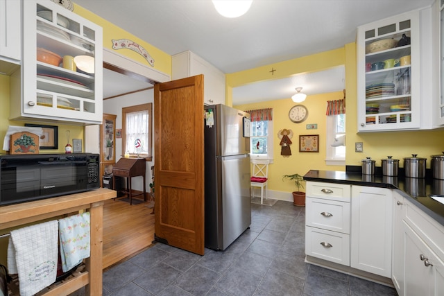 708 S Laurel St, Royal Oak, MI 48067 - kitchen featuring freestanding refrigerator, dark countertops, glass insert cabinets, and white cabinets