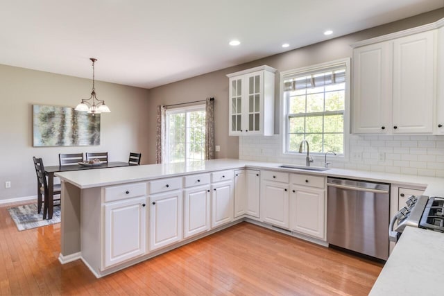 3352 Hampstead Ct, Portage, MI 49024 - kitchen featuring appliances with stainless steel finishes, a peninsula, light wood-type flooring, a chandelier, and light countertops