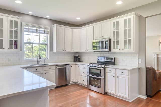 3352 Hampstead Ct, Portage, MI 49024 - kitchen with appliances with stainless steel finishes, a sink, light wood-type flooring, white cabinetry, and recessed lighting
