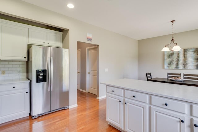 3352 Hampstead Ct, Portage, MI 49024 - kitchen with stainless steel fridge, light wood-style floors, light countertops, white cabinets, and recessed lighting