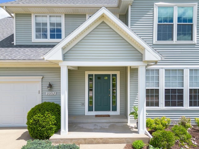 3352 Hampstead Ct, Portage, MI 49024 - property entrance featuring a shingled roof, a porch, and an attached garage