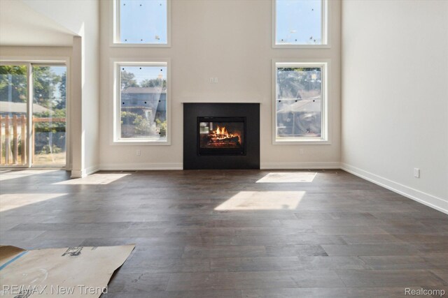 2911 Walsh Dr, Rochester Hills, MI 48309 - unfurnished living room with a glass covered fireplace, wood finished floors, a towering ceiling, and baseboards