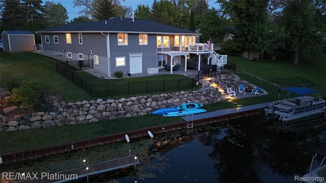 13368 Fenton Rd, Fenton, MI 48430 - rear view of house featuring a patio, a deck with water view, and stairs
