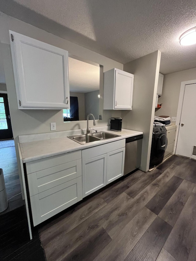 6530 Blue Lake Rd, Twin Lake, MI 49457 - kitchen featuring a sink, washing machine and clothes dryer, dark wood-style floors, stainless steel dishwasher, and white cabinets