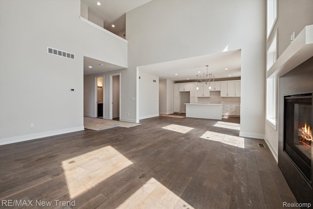 2921 Walsh Dr, Rochester Hills, MI 48309 - unfurnished living room featuring a high ceiling, a glass covered fireplace, dark wood finished floors, baseboards, and recessed lighting