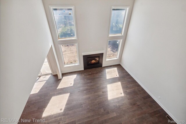 2921 Walsh Dr, Rochester Hills, MI 48309 - unfurnished living room with a lit fireplace, dark wood-style floors, and baseboards