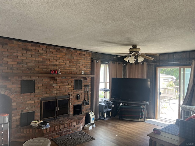 760 W Michigan Ave, Adrian, MI 49221 - living room with a textured ceiling, wood finished floors, ceiling fan, and a brick fireplace