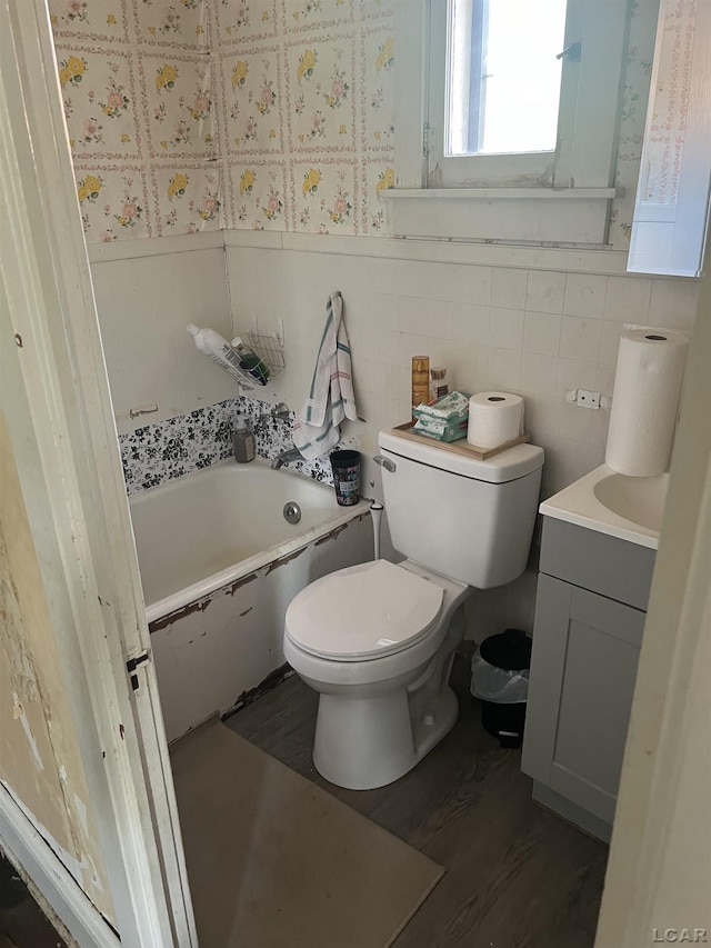 760 W Michigan Ave, Adrian, MI 49221 - bathroom featuring a bath, vanity, toilet, wood finished floors, and wainscoting