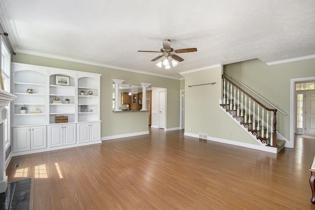 6541 S 6th St, Kalamazoo, MI 49008 - unfurnished living room with ceiling fan, stairway, wood finished floors, crown molding, and a fireplace with flush hearth