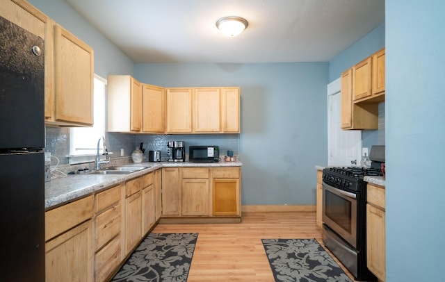 13 Rena St SW, Grand Rapids, MI 49507 - kitchen featuring black appliances, light brown cabinetry, a sink, and light wood-style floors