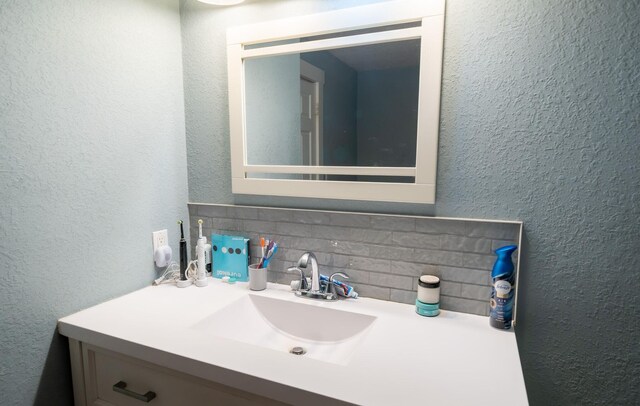 13 Rena St SW, Grand Rapids, MI 49507 - bathroom with a textured wall, vanity, and backsplash