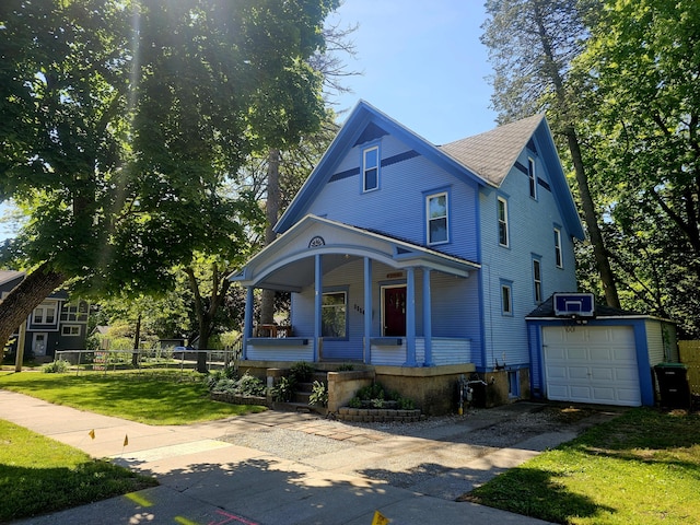 1114 E Michigan Ave, Albion, MI 49224 - victorian home featuring driveway, covered porch, an outbuilding, a front yard, and roof with shingles