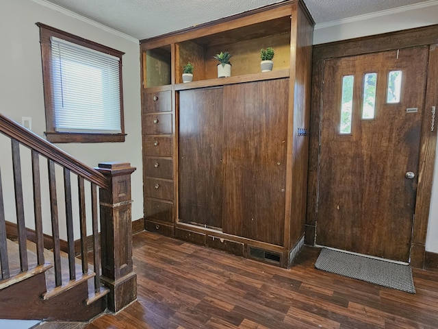 1114 E Michigan Ave, Albion, MI 49224 - entryway with dark wood-type flooring, crown molding, stairs, a textured ceiling, and baseboards