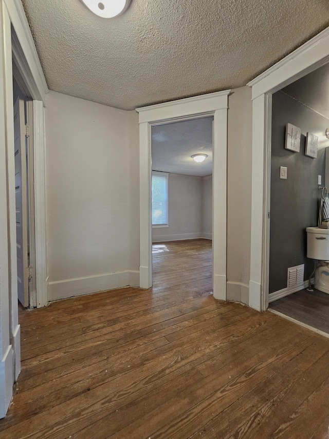 1114 E Michigan Ave, Albion, MI 49224 - hallway with wood finished floors, a textured ceiling, and baseboards