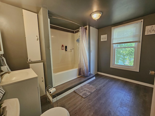 1114 E Michigan Ave, Albion, MI 49224 - full bathroom featuring wood finished floors, baseboards, shower / bath combo, toilet, and vanity