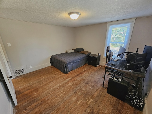 1114 E Michigan Ave, Albion, MI 49224 - bedroom with a textured ceiling, wood finished floors, an office area, and baseboards