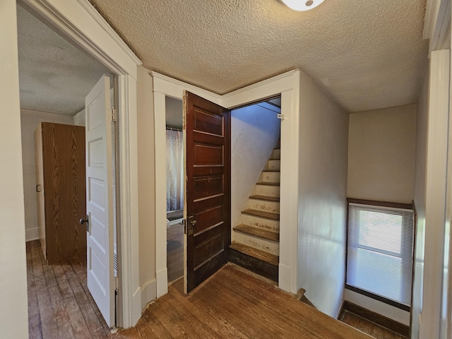 1114 E Michigan Ave, Albion, MI 49224 - corridor featuring a textured ceiling, wood finished floors, stairs, and baseboards