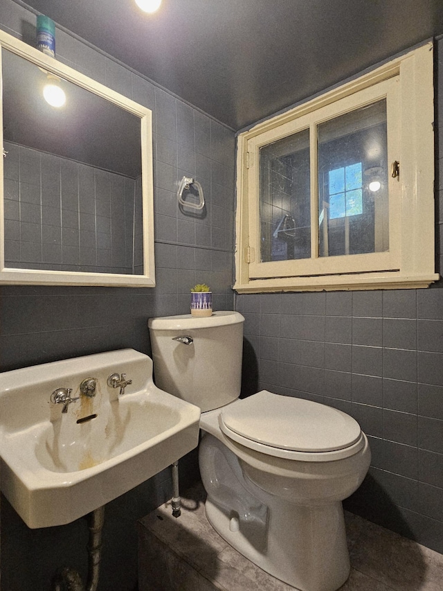 1114 E Michigan Ave, Albion, MI 49224 - bathroom featuring tile walls, toilet, and a sink