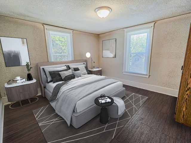 1114 E Michigan Ave, Albion, MI 49224 - bedroom featuring a textured wall, a textured ceiling, dark wood-style flooring, and baseboards