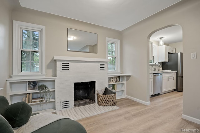 28517 Aberdeen St, Southfield, MI 48076 - living area featuring light wood-style flooring, arched walkways, healthy amount of natural light, and baseboards