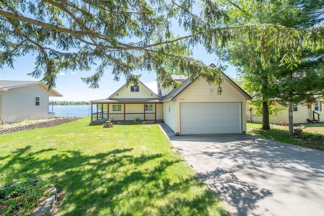 7945 W Royal Rd, Canadian Lakes, MI 49346 - view of front of property with driveway, a garage, a front lawn, a water view, and a porch