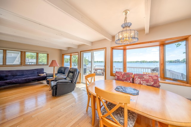 7945 W Royal Rd, Canadian Lakes, MI 49346 - dining room with beam ceiling, a chandelier, light wood-style floors, and a water view