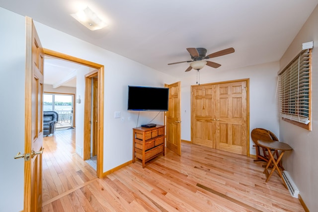 7945 W Royal Rd, Canadian Lakes, MI 49346 - living area with light wood-style floors, ceiling fan, baseboards, and a baseboard radiator
