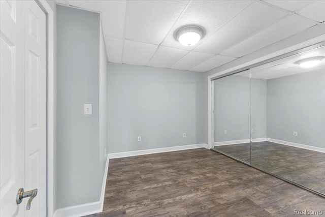 10161 N Loma Cir, Grosse Ile, MI 48138 - unfurnished bedroom featuring wood finished floors, baseboards, a drop ceiling, and a closet